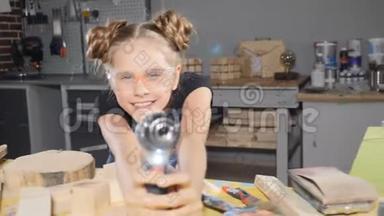 10岁的木木工女的画像，手持电子钻，对着镜头摆姿势。 小小的建筑理念。 <strong>高清高清</strong>